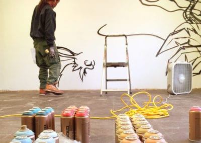 Mural artist, Seven, sketches a new mural with Montana Gold spray paint.